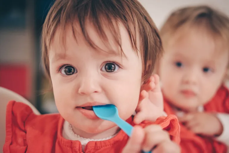 toddler putting spoon in mouth